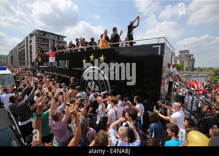 Berlin, Germany. 15th July, 2014. Germany's players wave and cheer to the fans as the coach with Germany's national soccer team drives past crowds of cheering fans on its way to the so-called 'Fan Meile' at the Brandenburg Gate, Berlin, 15 July 2014. The German team won the Brazil 2014 FIFA Soccer World Cup final against Argentina by 1-0 on 13 July 2014, winning the world cup title for the fourth time after 1954, 1974 and 1990. PHOTO: JAN WOITAS/dpa/Alamy Live News Stock Photo