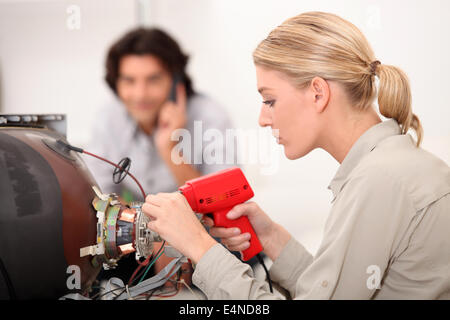 TV repairwoman with a soldering gun Stock Photo