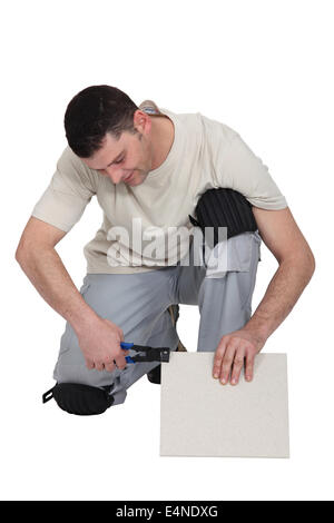 Man cutting tile to right size Stock Photo