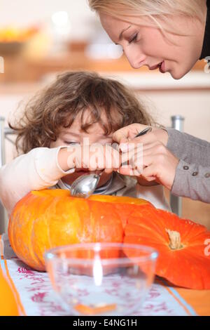 mother and her child emptying a pumpkin Stock Photo