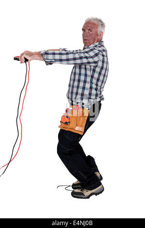 Electrocuted man holding jumper cables Stock Photo