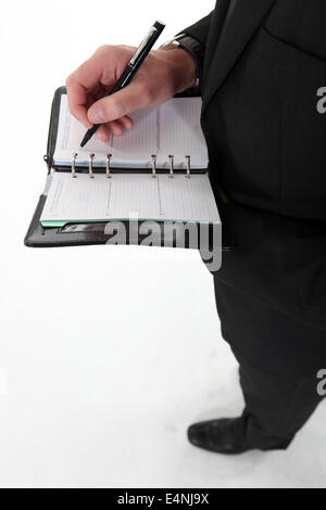 Businessman writing in agenda Stock Photo