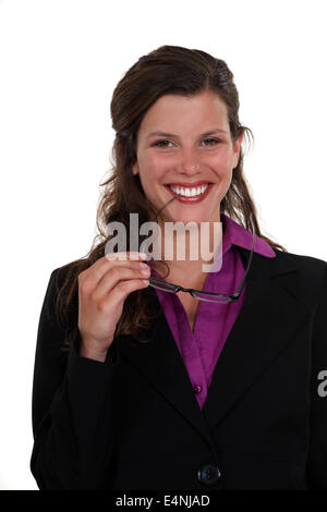 Woman nibbling at the frame of her glasses Stock Photo