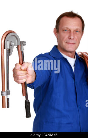 Plumber using tool to bend copper pipe Stock Photo