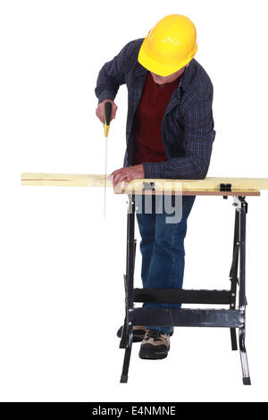 Man sawing plank of wood Stock Photo