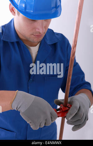 Plumber cutting copper pipe Stock Photo