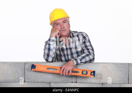 Bored tradesman holding a spirit level Stock Photo