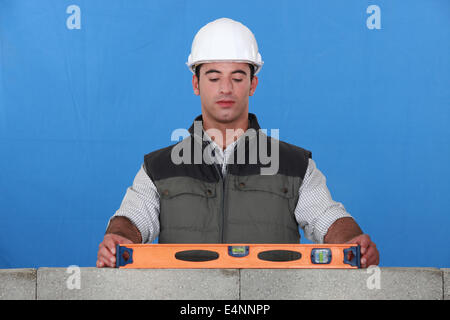 Bricklayer with a spirit level Stock Photo