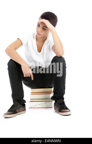 Teenage boy sitting on books waiting Stock Photo