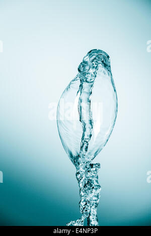 blue water splash rising up isolated on blue background Stock Photo