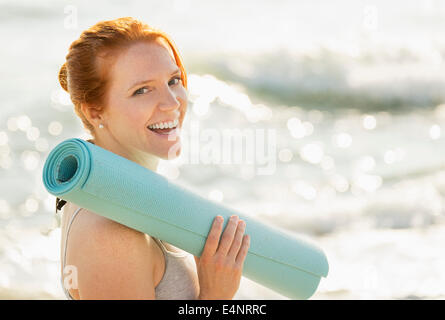 USA, Florida, Palm Beach, Portrait of woman holding yoga mat Stock Photo