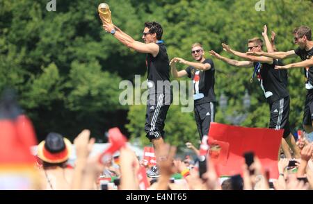 Berlin, Germany. 15th July, 2014. Germany's players stand on stage cheer and celebrate during the welcome reception for Germany's national soccer team in front of the Brandenburg Gate, Berlin, Germany, 15 July 2014. The German team won the Brazil 2014 FIFA Soccer World Cup final against Argentina by 1-0 on 13 July 2014, winning the world cup title for the fourth time after 1954, 1974 and 1990. Photo: Jens Wolf/dpa/Alamy Live News Stock Photo