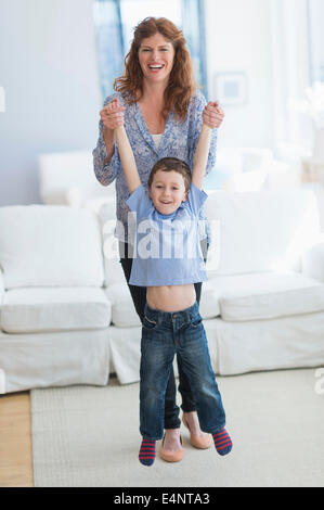 Mother and son (6-7) playing in living room Stock Photo