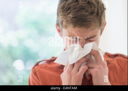 Teenage boy (16-17) blowing nose Stock Photo