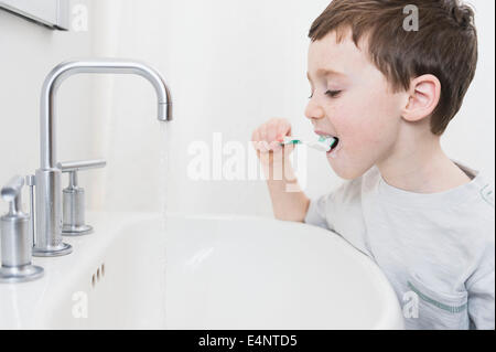 Boy (6-7) brushing teeth Stock Photo