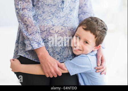 Boy (6-7) embracing mother Stock Photo