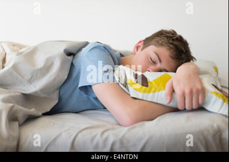 Teenage boy (16-17) sleeping in bed Stock Photo