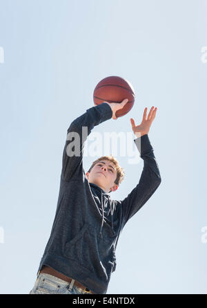 Teenage boy (16-17) playing basketball Stock Photo