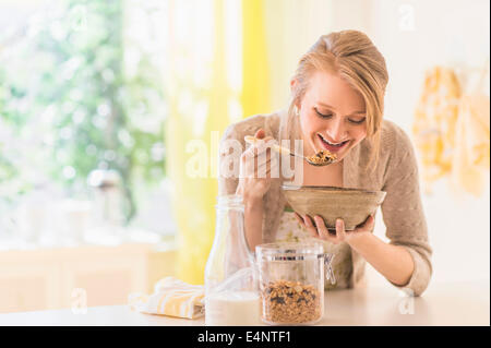 Young woman eating granola for breakfast Stock Photo