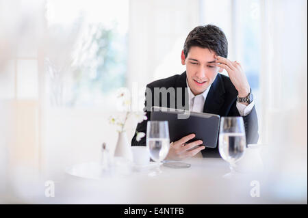 Portrait of business man using digital tablet in restaurant Stock Photo
