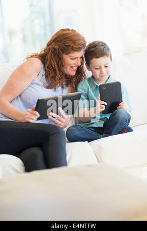 Mother and son (6-7) using digital tablets Stock Photo
