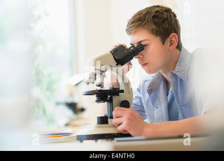 Teenage boy (16-17) looking through microscope Stock Photo