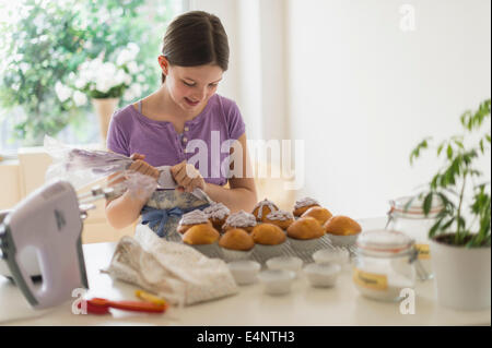 Girl (10-11) decorating cakes Stock Photo