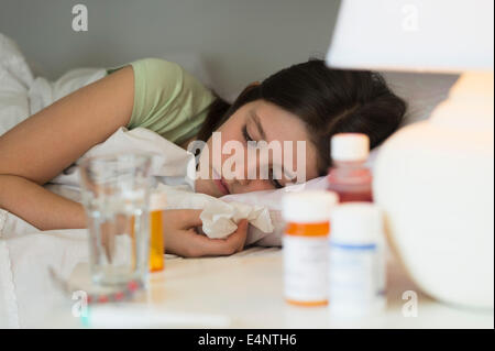 Sick girl (8-9) lying in bed Stock Photo