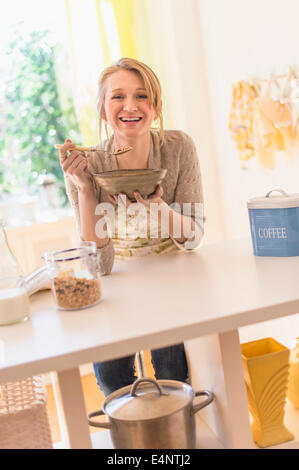 Young woman eating granola for breakfast Stock Photo