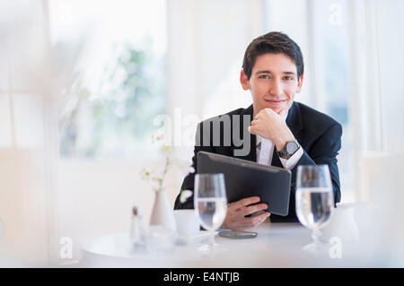 Portrait of business man using digital tablet in restaurant Stock Photo
