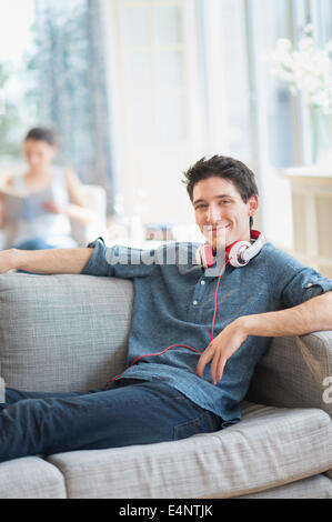 Man sitting on sofa, woman in background Stock Photo