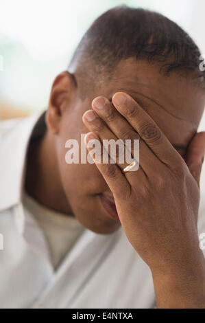 Sad man covering face with hand Stock Photo