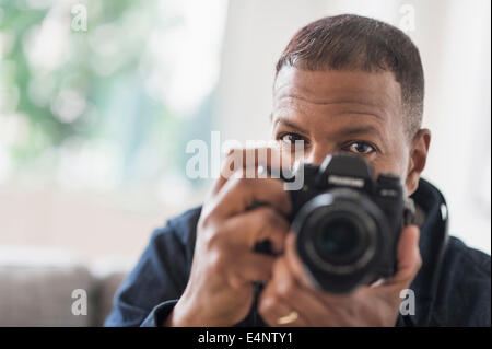 Portrait of man holding digital camera Stock Photo