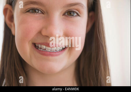 Girl (10-11) wearing dental braces smiling Stock Photo