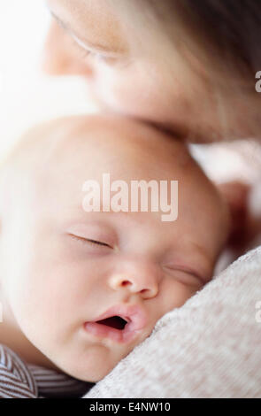 Close up of baby boy (2-5 months) sleeping on mother's shoulder Stock Photo