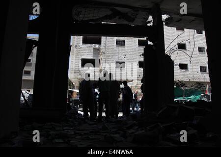 Gaza City, Gaza Strip, Palestinian Territory. 15th July, 2014. Palestinians inspect a destroyed building following an Israeli airstrike in Gaza city on July 15, 2014. Israel approved an Egyptian-proposed deal that would halt the week-old Gaza shelling war on Tuesday but the Palestinian territory's dominant Hamas Islamists responded suspiciously, saying they had not been consulted by Cairo. Israel said there had been two cross-border launches overnight that caused no damage, and that it had bombed 25 sites in Gaza.  Credit:  ZUMA Press, Inc./Alamy Live News Stock Photo