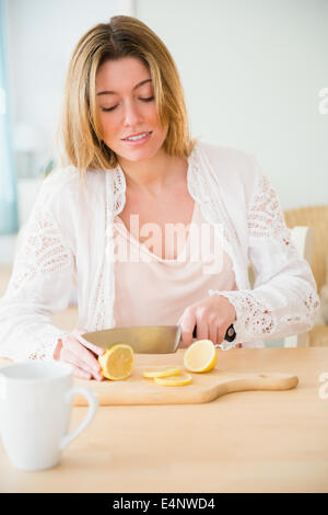 Young woman cutting lemon Stock Photo