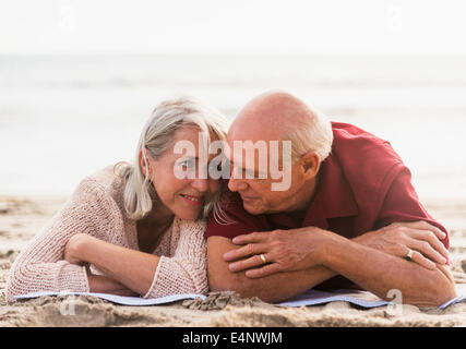 Senior couple lying on beach Stock Photo