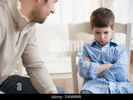 Father looking at displeased son (8-9) Stock Photo