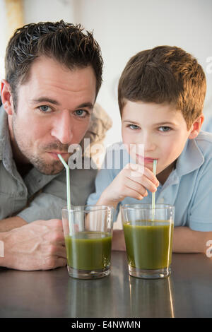 Father and son (8-9) drinking juice Stock Photo