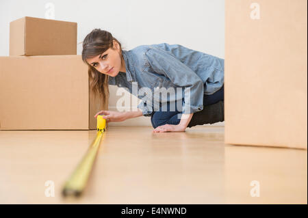 Young woman measuring floor Stock Photo