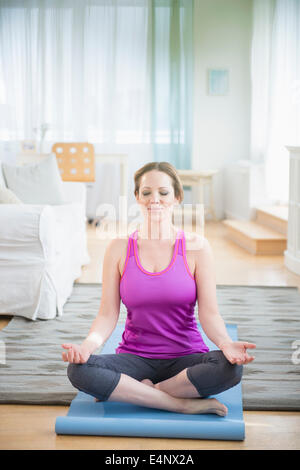 Woman meditaing at home Stock Photo