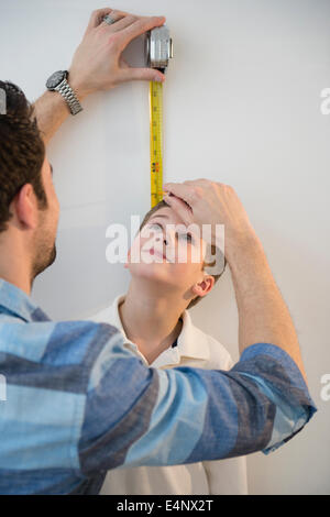 Father measuring height of son (8-9) Stock Photo