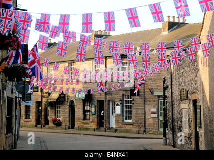 Union Jack bunting flying above a town centre shopping street in Bakewell; an historic English market town - summer, UK Stock Photo