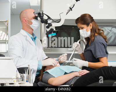 Dentist operation on patient and using microscope Stock Photo