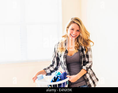 Portrait of woman holding laundry basket Stock Photo