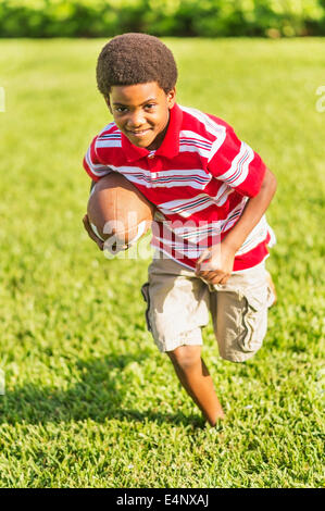 Boy (6-7) playing football Stock Photo