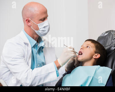Dentist checking mouth of patient (12-13) Stock Photo