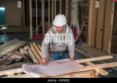 Engineer examining blueprint inside new structure Stock Photo