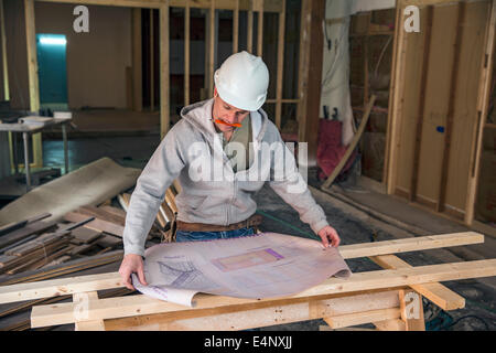 Engineer examining blueprint inside new structure Stock Photo